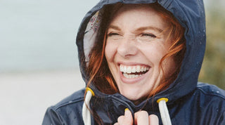 lachende Frau in Regenjacke