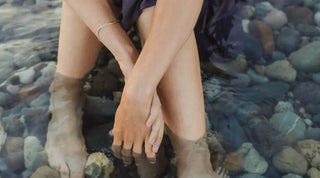 Frau, die mit ihren Füßen in einem Bach steht