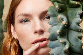 Frau hält sich die Lippe wegen Herpes