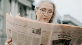 Ältere Frau liest Zeitung