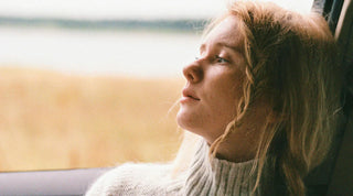 Frau sitzt im Auto und schaut aus dem Fenster