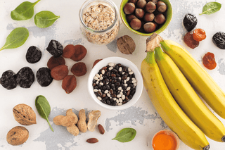 High carb Lebensmittel, Banane, Datteln, Nüsse auf einem Tisch