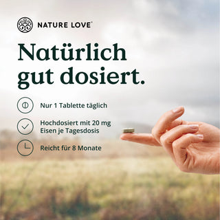 Eine Frau hält eine Nature Love Eisen & Vitamin C Tabletten darauf.