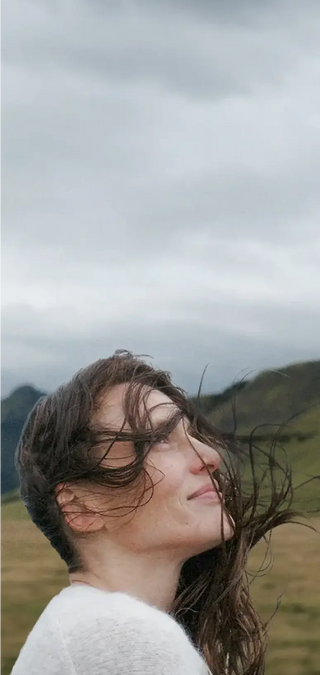 Eine Frau mit langen Haaren auf einem Feld.