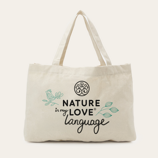 Der Jutebeutel von Nature Love ist eine beigefarbene Canvas-Tasche mit zwei Henkeln, auf deren Vorderseite ein Vogel, Blätter und "Nature is my love language" aufgedruckt sind.