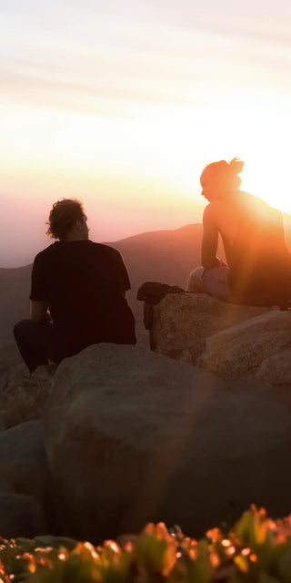 Ein Mann und eine Frau sitzen auf Felsen.