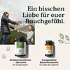 Eine Frau und ein Kind geben sich in den Bergen ein High-Five und zeigen zwei Nature Love Probiona - Family-Set Flaschen (für Erwachsene und Kinder) mit einem deutschen Text, der die Darmgesundheit fördert.