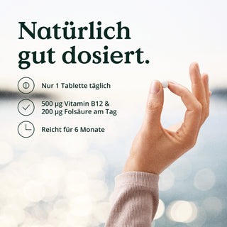 Eine Frau hält eine Nature Love-Tablette mit der Aufschrift Vitamin B12 500 µg mit Folat Tabletten hochdosiert hoch.